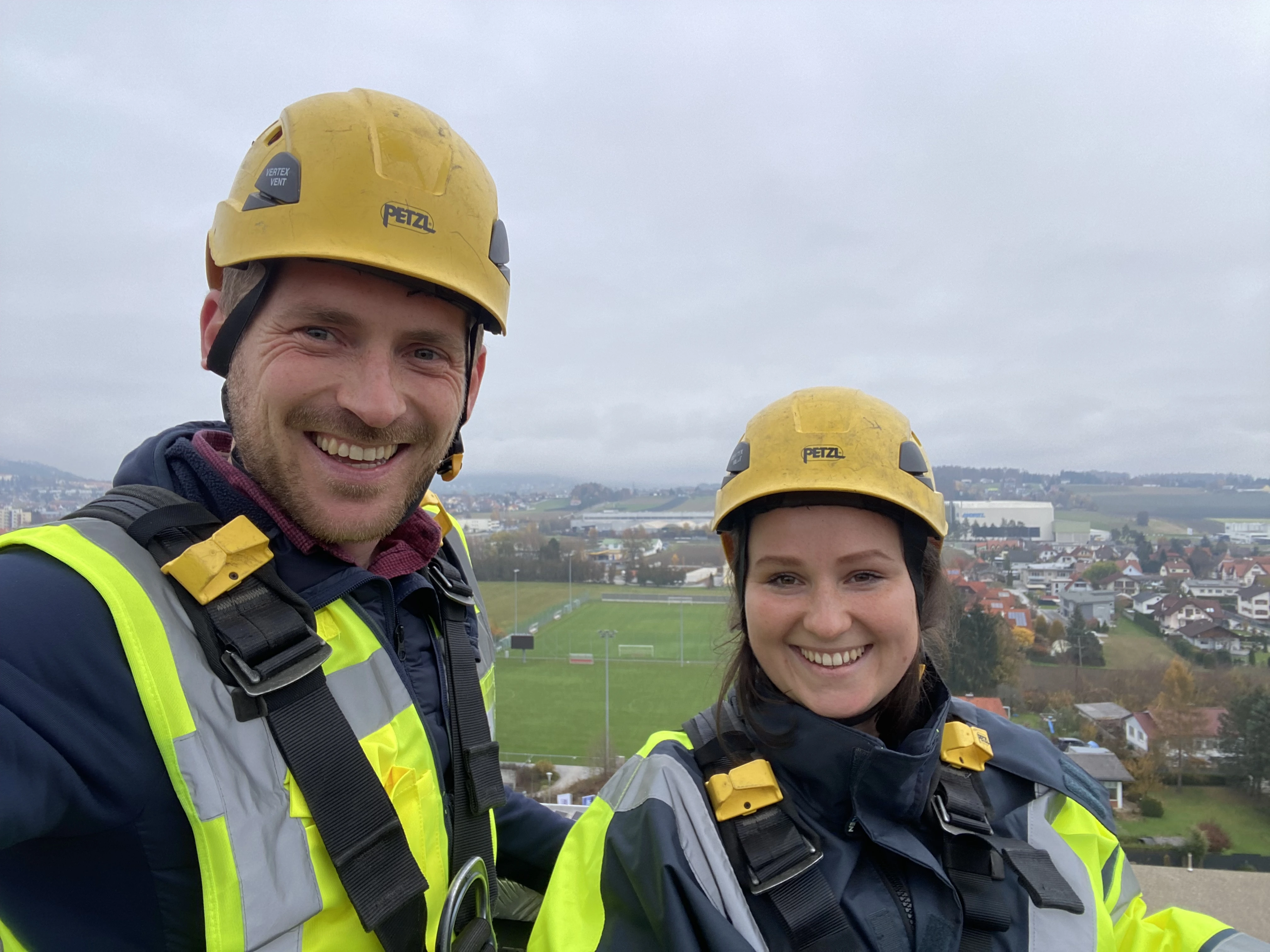 Martina Fritzel gemeinsam mit einem Kollegen mit Schutzweste und Helm bei der Montage